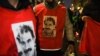 Participants wearing jerseys with the face of Abdullah Ocalan, leader of the Kurdistan Worker's Party (PKK), gather to take part in a tribute to the three persons killed, in front of the 'Centre democratique du Kurdistan' in Paris, Dec. 24, 2022. 