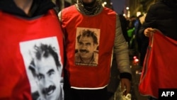 Participants wearing jerseys with the face of Abdullah Ocalan, leader of the Kurdistan Worker's Party (PKK), gather to take part in a tribute to the three persons killed, in front of the 'Centre democratique du Kurdistan' in Paris, Dec. 24, 2022. 