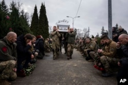 Ukrainian servicemen of Khartia battalion carry the coffin of Vladyslava Chernyh 'Aida' during a funeral ceremony at the cemetery in Kharkiv, Ukraine, Dec. 30, 2022.