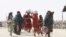 FILE - People from Afghanistan walk with their belongings as they cross into Pakistan at the 'Friendship Gate' crossing point, in the Pakistan-Afghanistan border town of Chaman, Pakistan, Sept. 7, 2021. 