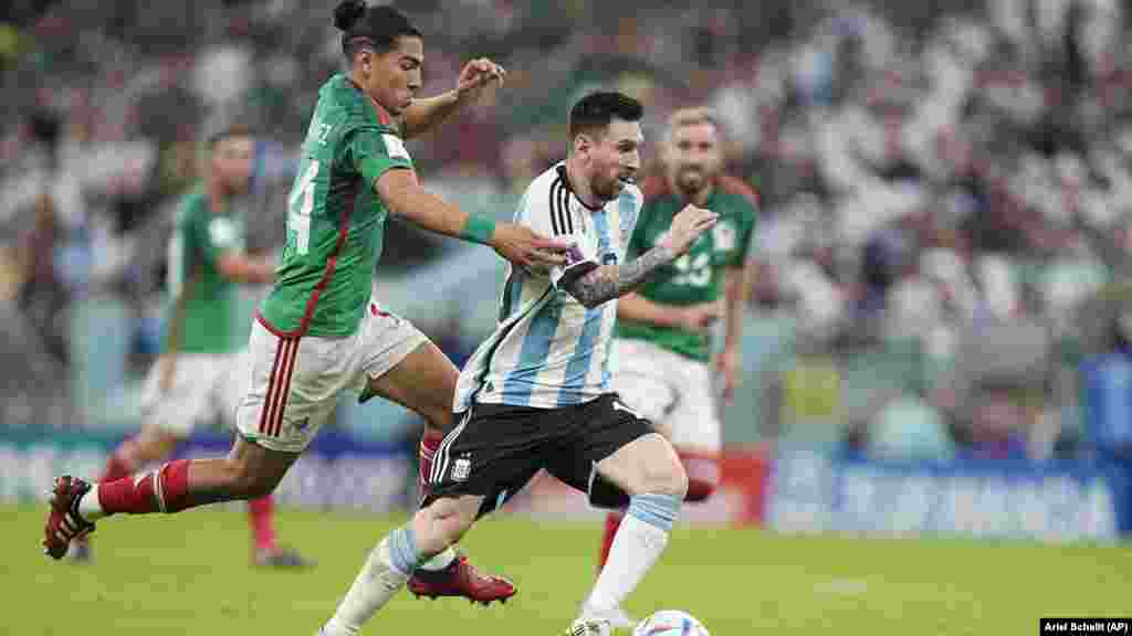 Lionel Messi corre com a bola enquanto o mexicano Erick Gutiérrez tenta travá-lo, no jogo Argentina x México, no estádio de Lusail, Mundial do Qatar. 26 Nov, 2022