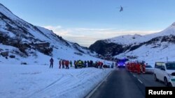 Rescue workers stand near the site where an avalanche reportedly buried 10 people in the Lech/Zuers free skiing area, on Arlberg, Austria, Dec. 25, 2022. (Police Vorarlberg/Handout via Reuters)