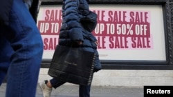 FILE - People walk along a shopping street in London, Britain, Dec. 26, 2022.