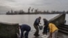 Los residentes de la ciudad recientemente liberada de Jersón recogen agua de la orilla del río Dnipro, cerca de la línea del frente, en el sur de Ucrania, el lunes 21 de noviembre de 2022. (Foto AP/Bernat Armangue)