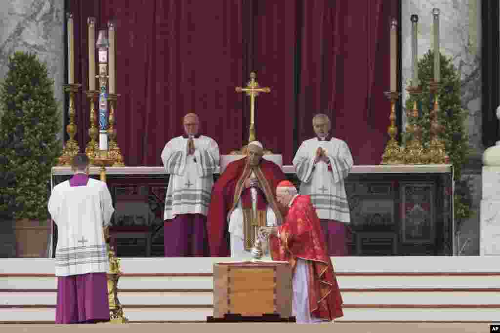 Pope Francis, center, watches as Cardinal Giovanni Battista Re, center right, blesses the coffin of late Pope Benedict XVI in St. Peter&#39;s Square at the Vatican, Jan. 5, 2023.