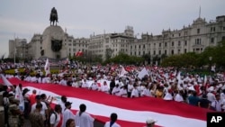 Demonstran berbaris sambil memegang bendera besar dalam aksi damai di alun-alun San Martin di Lima, Peru, Selasa, 3 Januari 2023. (AP/Martin Mejia)