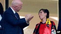 Belgium Foreign Minister Hadja Lahbib, wearing a 'One Love' armband, talks with FIFA President Gianni Infantino, left, during a World Cup match in Doha, Qatar, Nov. 23, 2022.