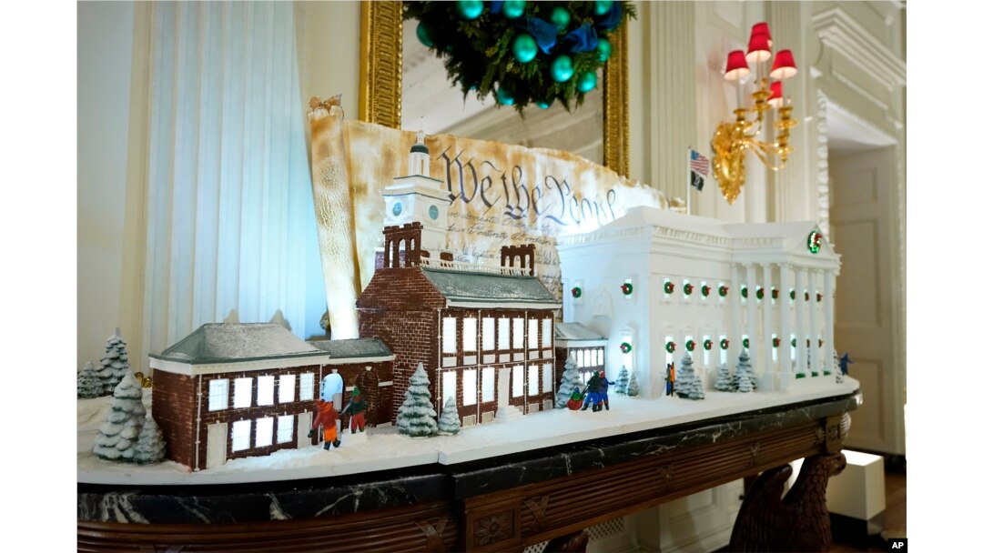 A sugar cookie replica of Independence Hall and a gingerbread replica of the White House are on display in the State Dining Room of the White House during a press preview of holiday decorations at the White House, Monday, Nov. 28, 2022, in Washington. (AP Photo/Patrick Semansky)