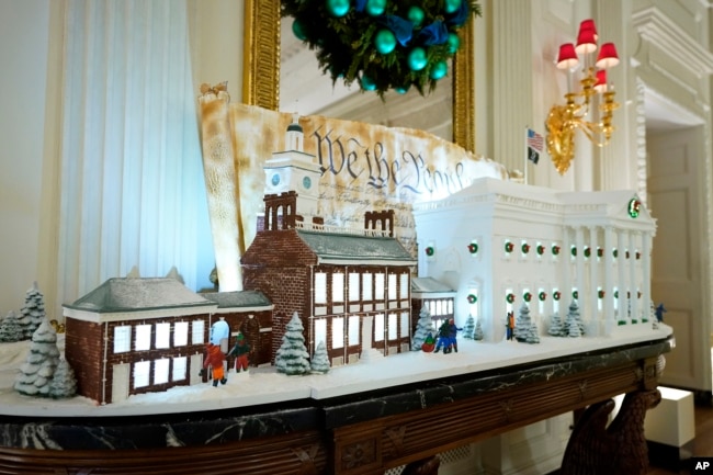 A sugar cookie replica of Independence Hall and a gingerbread replica of the White House are on display in the State Dining Room of the White House during a press preview of holiday decorations at the White House, Monday, Nov. 28, 2022, in Washington. (AP Photo/Patrick Semansky)