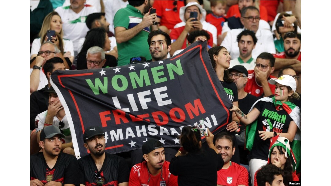 Para suporter Tim Sepakbola Iran memegang spanduk bertuliskan 'Kebebasan hidup perempuan' di dalam stadion selama pertandingan Tim Piala Dunia Grup B antara kesebelasan Iran melawan Inggris, di Stadion Internasional Khalifa, Doha, Qatar, 21 November 2022 REUTERS/Paul Childs