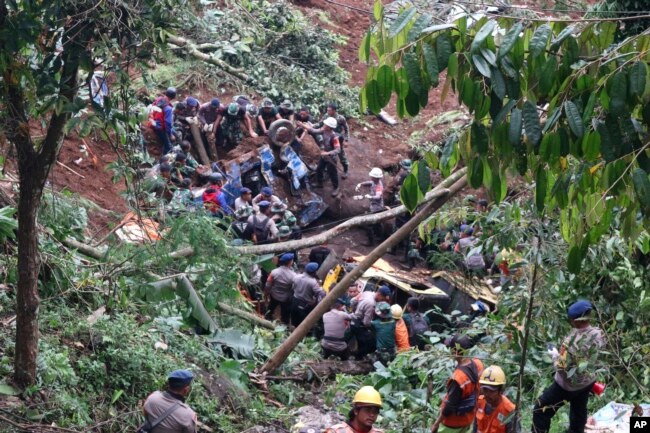 Tim penyelamat memindahkan rongsokan kendaraan yang rusak akibat tanah longsor yang dipicu gempa di Cianjur, Jawa Barat, Senin, 21 November 2022. (AP Photo/Rangga Firmansyah)