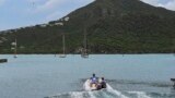 FILE - Tourists sit on a boat in English Harbour, Antigua and Barbuda, on Sept. 18, 2022. 