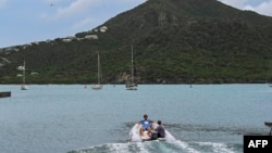 FILE - Tourists sit on a boat in English Harbour, Antigua and Barbuda, on Sept. 18, 2022. 