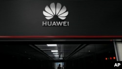 FILE - A technician stands at the entrance to a Huawei 5G data server center in Guangzhou, in southern China's Guangdong province, Sept. 26, 2021. 