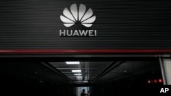 FILE - A technician stands at the entrance to a Huawei 5G data server center in Guangzhou, in southern China's Guangdong province on Sept. 26, 2021. 