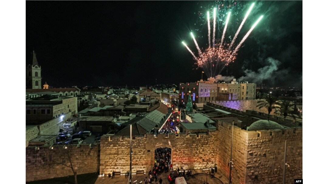 Kembang api menerangi langit saat warga menghadiri penyalaan pohon Natal di Gerbang Jaffa, kota tua Yerusalem, 11 Desember 2022. (AHMAD GHARABLI/AFP)