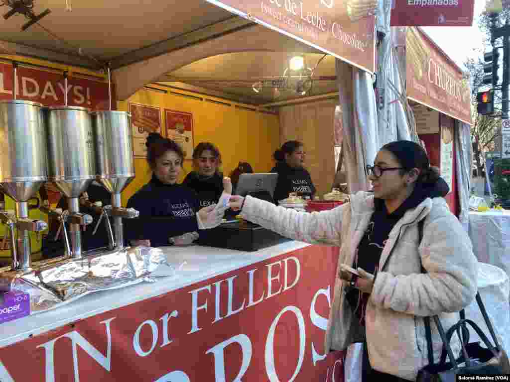 Un grupo de latinos trabaja vendiendo churros y empanadas al público del Downtown Holiday Market en Washington D.C.