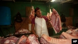 A meat vendor sells pork at a private market in Havana, Dec. 23, 2022.