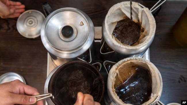 Students stir tea in a pot during a class on making Hong Kong-style milk tea at the Institute of Hong Kong Milk Tea in Hong Kong on Nov. 3, 2022.