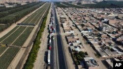 Truckers are backed up on the Pan-American North highway as supporters of ousted Peruvian President Pedro Castillo block it to protest his detention in Viru, Peru, Dec.15, 2022.