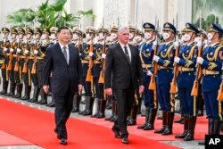 Presiden China Xi Jinping (kiri) dan Presiden Kuba Miguel Diaz-Canel Bermudez meninjau pasukan kehormatan saat upacara penyambutan di Aula Besar Rakyat di Beijing, Jumat, 25 November 2022. (Ding Lin/Xinhua melalui AP)