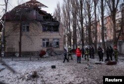 Rescuers and police officers examine parts of the drone at the site of a building destroyed by a Russian drone attack, as their attack on Ukraine continues, in Kyiv, Ukraine December 14, 2022. (REUTERS/Gleb Garanich)