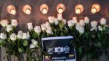Flores, velas y un cartel que dice "Ni uno más" se ven durante el funeral del periodista ecuatoriano de El Comercio Javier Ortega, el fotógrafo Paul Rivas y el conductor Efraín Segarra en Cali, Colombia el 26 de junio de 2018.