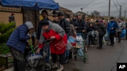 Residents queue to fill containers with drinking water in recently liberated Kherson, southern Ukraine, Nov. 20, 2022.