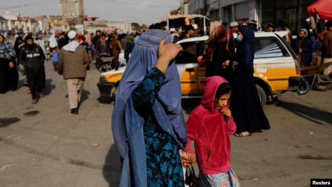 FILE - An Afghan woman and a girl walk in a street in Kabul, Afghanistan, November 9, 2022.