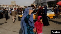 Una mujer y una niña caminan por una calle de Kabul, Afganistán, el 9 de noviembre de 2022.