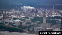 FILE - The Exxon Mobil Baton Rouge Refinery complex with the Louisiana State Capitol, bottom right, in Baton Rouge, La., Monday, April 11, 2022. (AP Photo/Gerald Herbert)