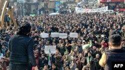 Demonstrators raise Syrian opposition flags and placards as they rally against a potential rapprochement between Ankara and the Syrian regime, on Dec. 30, 2022.