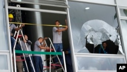 Workers measure the windows of Planalto Palace, the office of the president, the day after it was stormed by supporters of Brazil's former President Jair Bolsonaro in Brasilia, Brazil, Jan. 9, 2023.