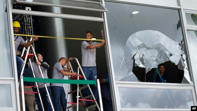 Workers measure the windows of Planalto Palace, the office of the president, the day after it was stormed by supporters of Brazil's former President Jair Bolsonaro in Brasilia, Brazil, Jan. 9, 2023.