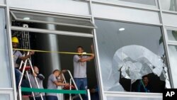 Workers measure the windows of Planalto Palace, the office of the president, the day after it was stormed by supporters of Brazil's former President Jair Bolsonaro in Brasilia, Brazil, Jan. 9, 2023.