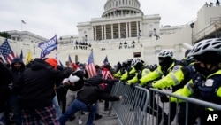 Pobunjenici lojalni predsjedniku Donaldu Trumpu pokušavaju da probiju policijsku barijeru oko Kapitola, 6. januara 2021. (Foto: AP/Julio Cortez, ARHIVA)
