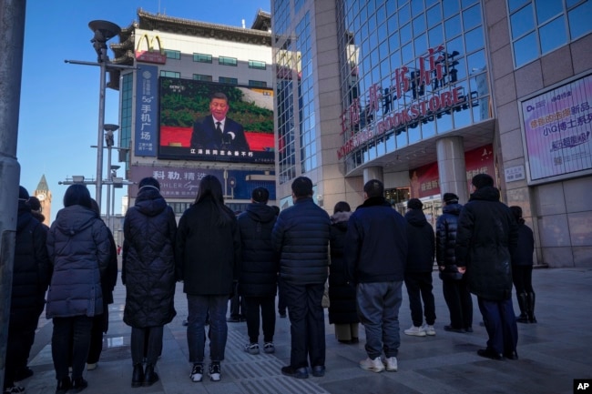 北京市民观看现场直播的习近平在江泽民追悼仪式上的讲话。（2022年12月6日）