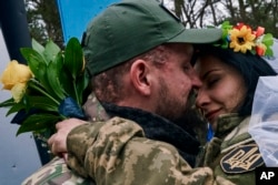 Ukrainian army medics Eugenia and Oleksander embrace after their wedding ceremony in Lyman on December 24, 2022. (Libkos/AP)