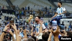 El argentino Leo Messi sostiene el trofeo de la Copa del Mundo tras vencer a Francia en los penales.