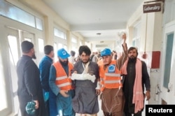 Rescue workers escort a man injured during cross-border shelling and gunfire, at a hospital in the Pakistan-Afghanistan border town of Chaman, Pakistan, Dec. 15, 2022.