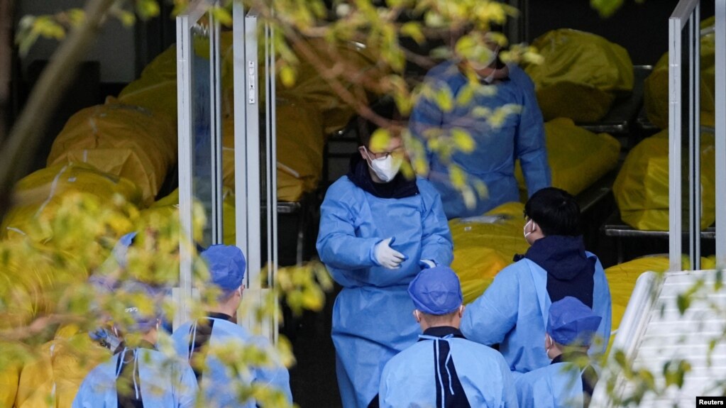 Nhân viên đứng bên cạnh một số túi đựng thi thể tại một nhà tang lễ, ở Thượng Hải, Trung Quốc, ngày 4 tháng 1 năm 2023.