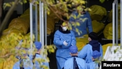 Nhân viên đứng bên cạnh một số túi đựng thi thể tại một nhà tang lễ, ở Thượng Hải, Trung Quốc, ngày 4 tháng 1 năm 2023.