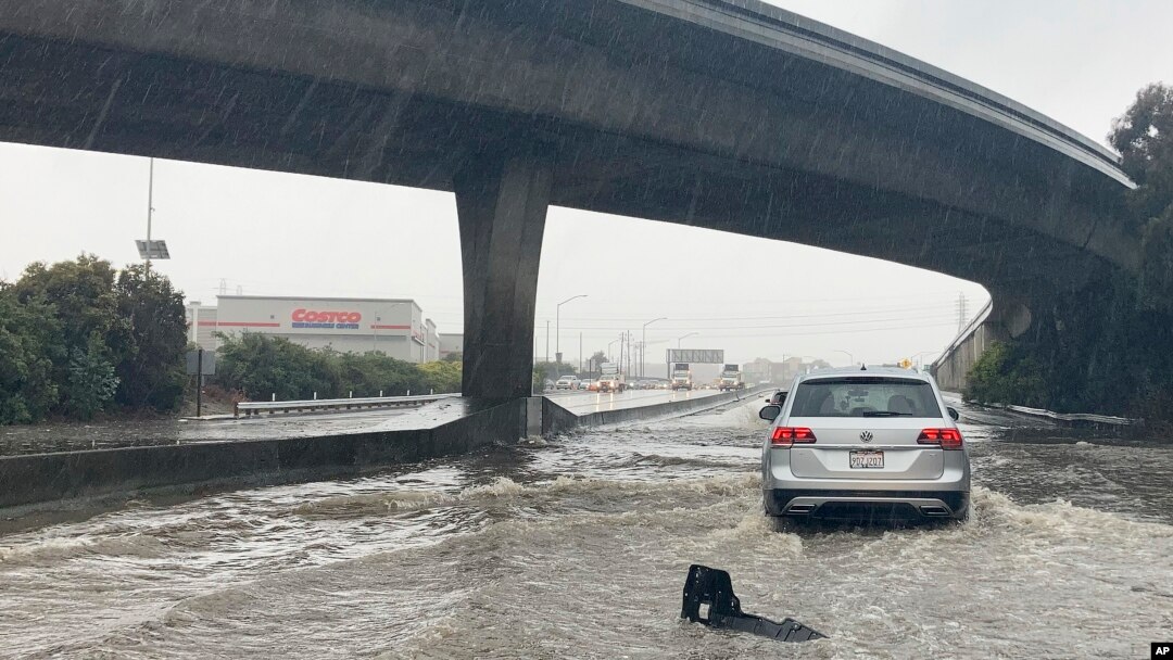 Traffic drives through flooded lanes on Highway 101 in South San Francisco, California, Dec. 31, 2022. A flood watch is in effect across much of Northern California through New Year's Eve. 