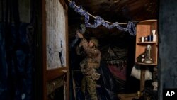 A Ukrainian soldier decorates a frontline position during fights with Russian forces near Maryinka, Donetsk region, Ukraine, Dec. 23, 2022. 