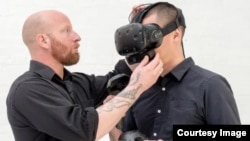 OVR Technology Manager Aaron Wisniewski shows off a wearable virtual reality device designed to produce realistic scents.  (Image credit: OVR Technology)