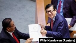 Yasonna Laoly, Menteri Hukum dan HAM, menerima laporan KUHP baru dari Bambang Wuryanto, dalam rapat paripurna parlemen di Jakarta, 6 Desember 2022. (Foto: REUTERS/Willy Kurniawan)