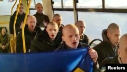 Ukrajinski vojnici pevaju nacionalnu himnu pošto su oslobođeni u sklopu razmene zatvorenika sa Rusijom, na nedefinisanoj lokaciji u Ukrajini, na fotografiji napravljenoj od video snimka, 8. janura 2022.