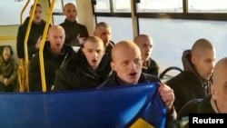 8일 우크라이나와 러시아의 포로 교환으로 풀려난 우크라이나 군인들이 버스 안에서 국가를 부르고 있다.