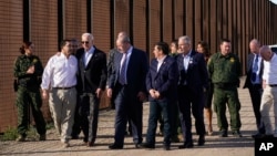 President Joe Biden talks with Rep. Henry Cuellar, a Democrat from Texas, second from left, as they walk along a stretch of the U.S.-Mexico border in El Paso Texas, Jan. 8, 2023. Homeland Security Secretary Alejandro Mayorkas is at right.