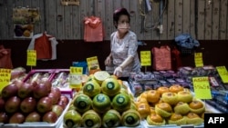 A vendor points to fruit at the Yau Ma Tei fruit market in Hong Kong on Nov. 22, 2022.